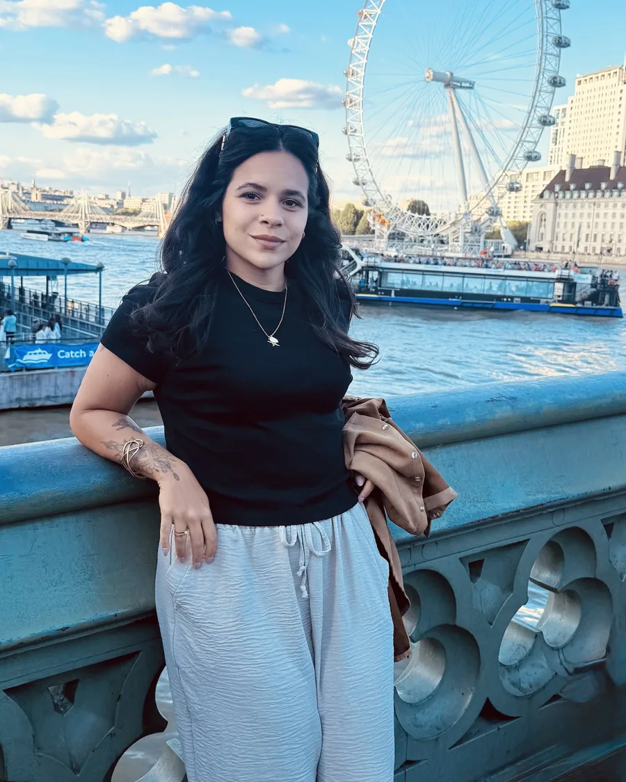 Alice Andrade on Westminster Bridge in London, with the London Eye behind her